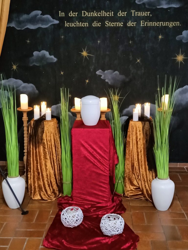 Bestatterin mit Herz Eine Reihe von brennenden Teelichtern auf einem dunklen Hintergrund.